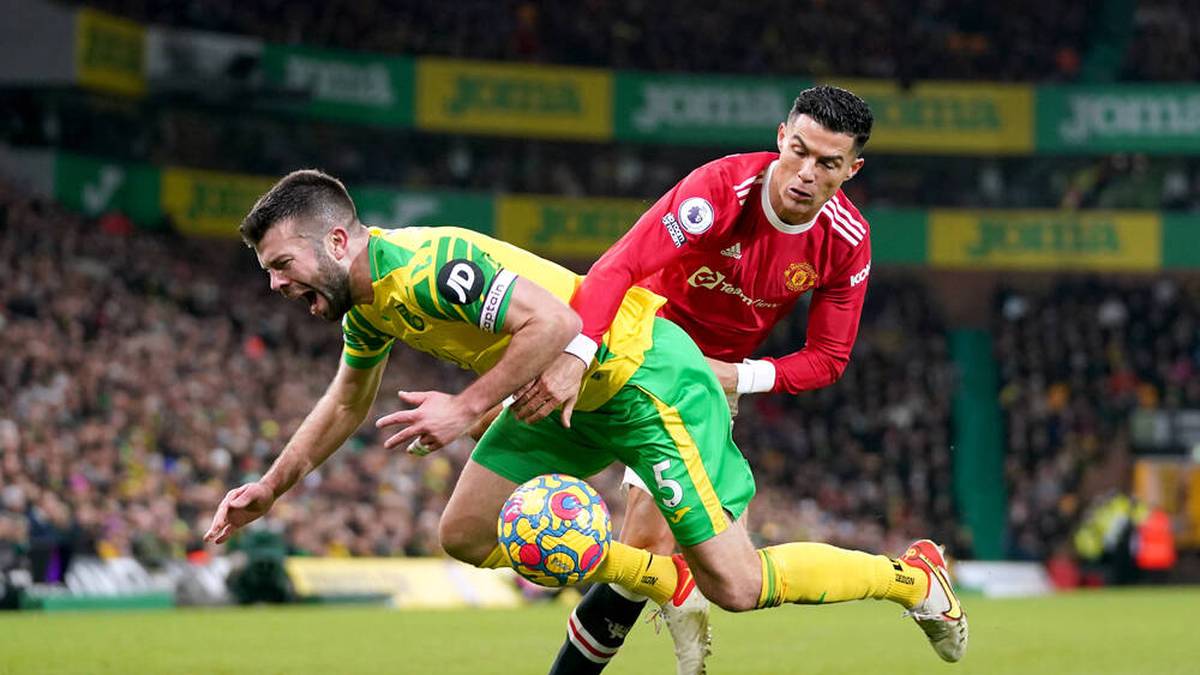 Norwich City v Manchester United, ManU - Premier League - Carrow Road Norwich City s Grant Hanley (left) falls as he battles for the ball with Manchester United s Cristiano Ronaldo during the Premier League match at Carrow Road, Norwich. Picture date: Saturday December 11, 2021. EDITORIAL USE ONLY No use with unauthorised audio, video, data, fixture lists, club league logos or live services. Online in-match use limited to 120 images, no video emulation. No use in betting, games or single club league player publications. PUBLICATIONxINxGERxSUIxAUTxONLY Copyright: xJoexGiddensx 64269628