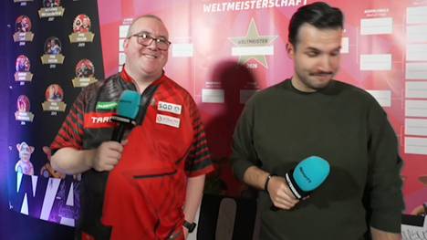 Stephen Bunting zeigt sich im Siegerinterview nach seiner Zweitrundenpartie bestens gelaunt. Mit SPORT1-Experte Philip Brzezinski scherzt der Engländer über den Bully Boy und dessen Fußballkenntnisse. 