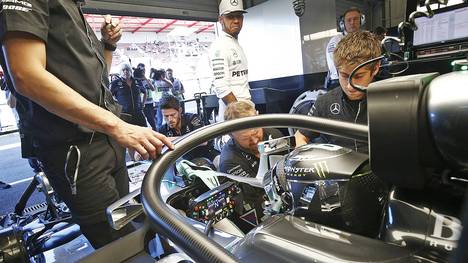 Lewis Hamilton schaut missmutig ins Cockpit des Pole-Setters Nico Rosberg