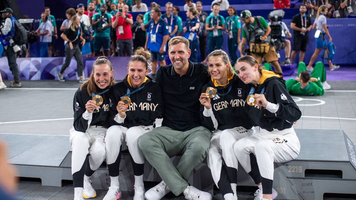 Basketball-Legende Dirk Nowitzki feiert gemeinsam mit den deutschen 3x3 Basketball-Damen Svenja Brunckhorst, Marie Reichert, Sonja Greinacher und Elisa Mevius (v.l.) den historischen Olympiasieg 