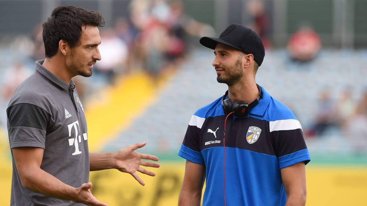 Neuzugang Mats Hummels (l.) sitzt zunächst nur auf der Bank. Beim Warmmachen nutzt der Weltmeister die Zeit für einen Plausch mit Jenas Filip Krstic, mit dem Hummels einst gemeinsam in der FCB-Jugend spielte