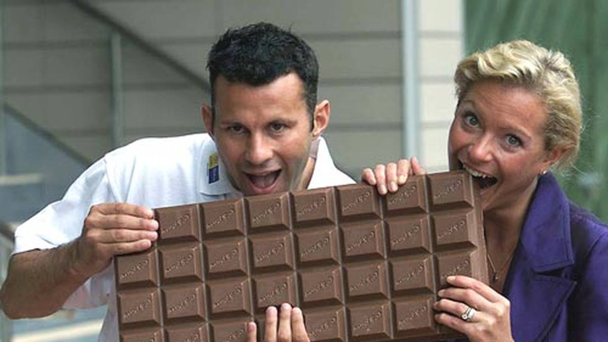 Die Commonwealth Games kommen 2002 nach Manchester. Giggs ist ein Repräsentant und beißt aus Werbezwecken gerne in diese überdimensionale Tafel Schokolade