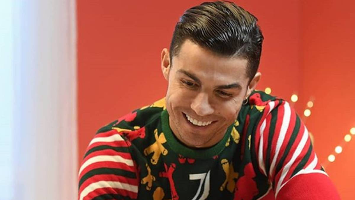 In einem Weihnachtspulli mit der Nummer 7 hat Cristiano sein schönstes Weinachtslächeln aufgesetzt. Vor ihm steht ein Panetone, der Lieblingskucheen der Italiener zum Fest 