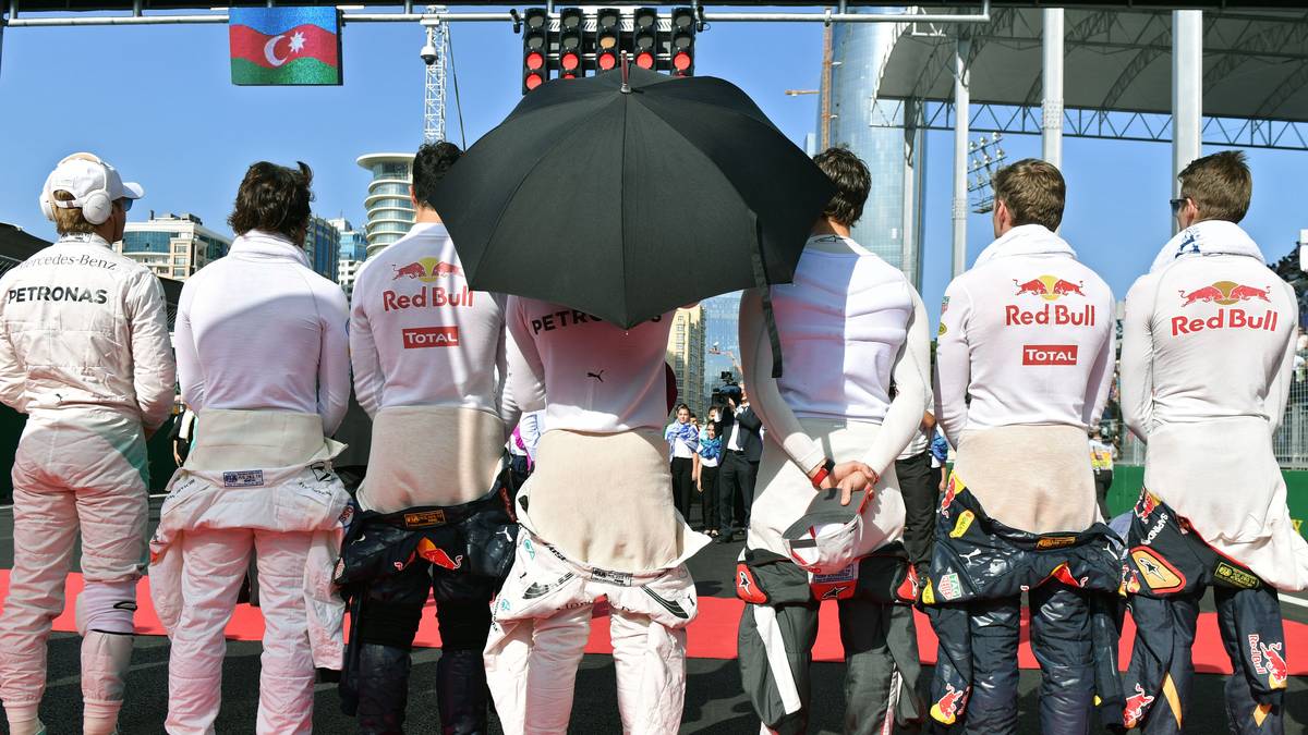 Hamilton lauscht  der Hymne  anschließend als einziger Fahrermit Sonnenschirm