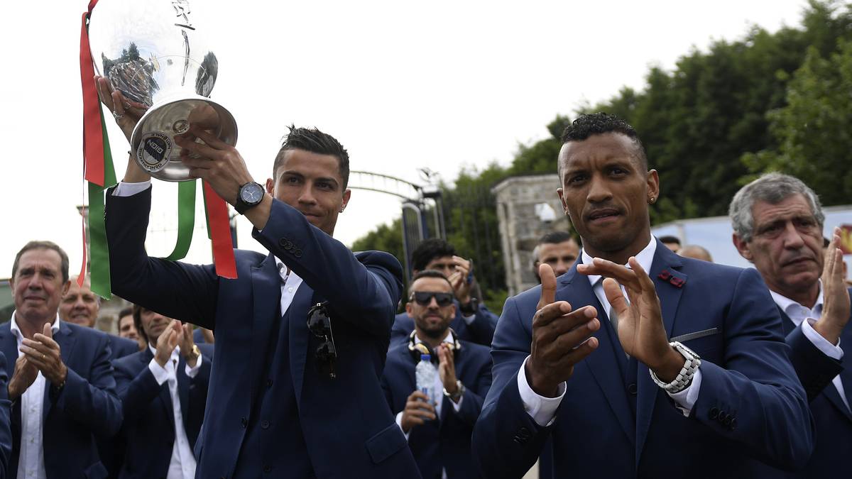 Beim Verlassen der Unterkunft der portugiesischen Mannschaft in Marcoussis präsentieren Cristiano Ronaldo (l.), Nani und Co. den EM-Pokal