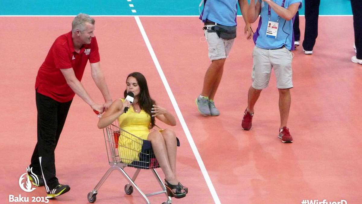 Ein Interview der etwas anderen Art: Eine Fernsehreporterin stellt ihre Fragen nach dem Viertelfinale der deutschen Volleyballer aus einem Einkaufswagen heraus. Der Bundestrainer macht den Spaß mit