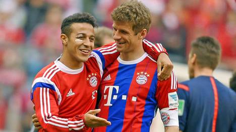 Der am Auge verletzte Thiago und Thomas Müller vom FC Bayern München feiern einen Sieg
