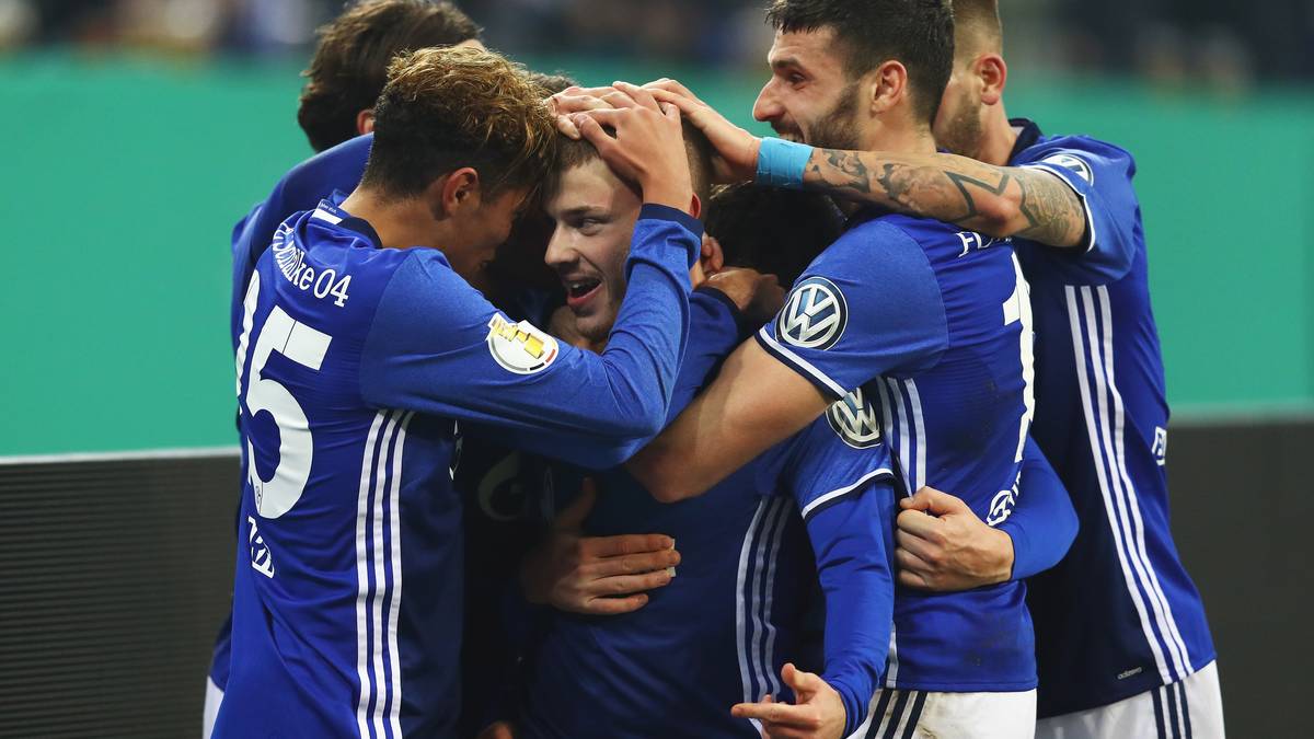 Der nur 1,73 Meter große Mittelfeldspieler wird von seinen Teamkollegen fast erdrückt