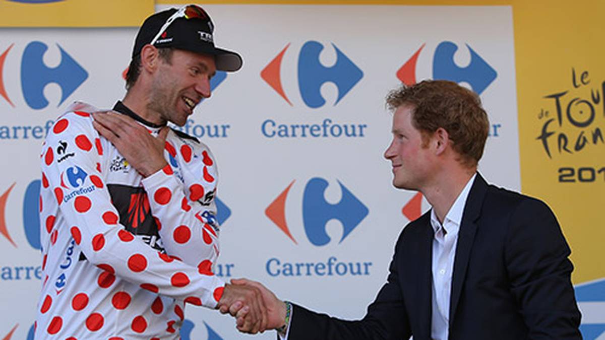 Oldie Jens Voigt (l.) darf sich nach der ersten Etappe das Bergtrikot überziehen. Erster Gratulant: Prinz Harry
