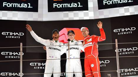 Lewis Hamilton (l. ) und Sebastian Vettel gefällt das neue Formel-1-Logo (oben) nicht