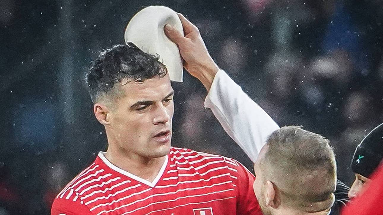 Ein Fan bei dem Versuch Granit Xhaka eine Qeleshe aufzusetzen