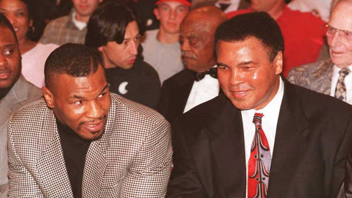 Sein kometenhafter Aufstieg und seine Dominanz im Ring  - Tyson schickt seine Gegner regelmäßig in den ersten Runden auf die Bretter - bringen ihm Vergleiche mit Box-Legenden wie Muhammad Ali (r., bei einem späteren Treffen 1995) ein 