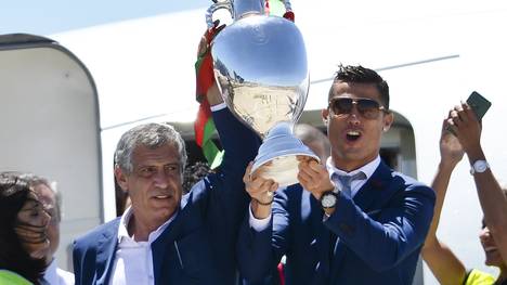 Trainer Fernando Santos (l.) und Cristiano Ronaldo sind mit dem Siegerpokal gelandet
