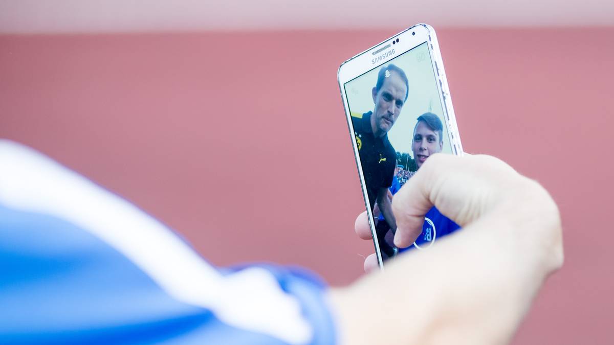 Mit einem Balljungen posiert er für ein Selfie
