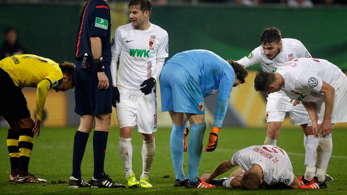 Wo gehobelt wird, fallen Späne: Augsburgs Ragnar Klavan bekommt einen mit, muss medizinisch  behandelt werden. Aber es kann für ihn weitergehen