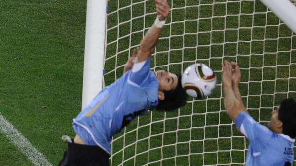 Uruguay's striker Luis Suarez (R) stops