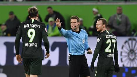 Wolfsburg's Dutch forward Wout Weghorst (L) and Wolfsburg's German midfielder Maximilian Arnold argue with the referee Felix Brych (C) during the German first division Bundesliga football match VfL Wolfsburg v Borussia Moenchengladbach in Wolfsburg, on December 15, 2019. (Photo by John MACDOUGALL / AFP) / DFL REGULATIONS PROHIBIT ANY USE OF PHOTOGRAPHS AS IMAGE SEQUENCES AND/OR QUASI-VIDEO (Photo by JOHN MACDOUGALL/AFP via Getty Images)
