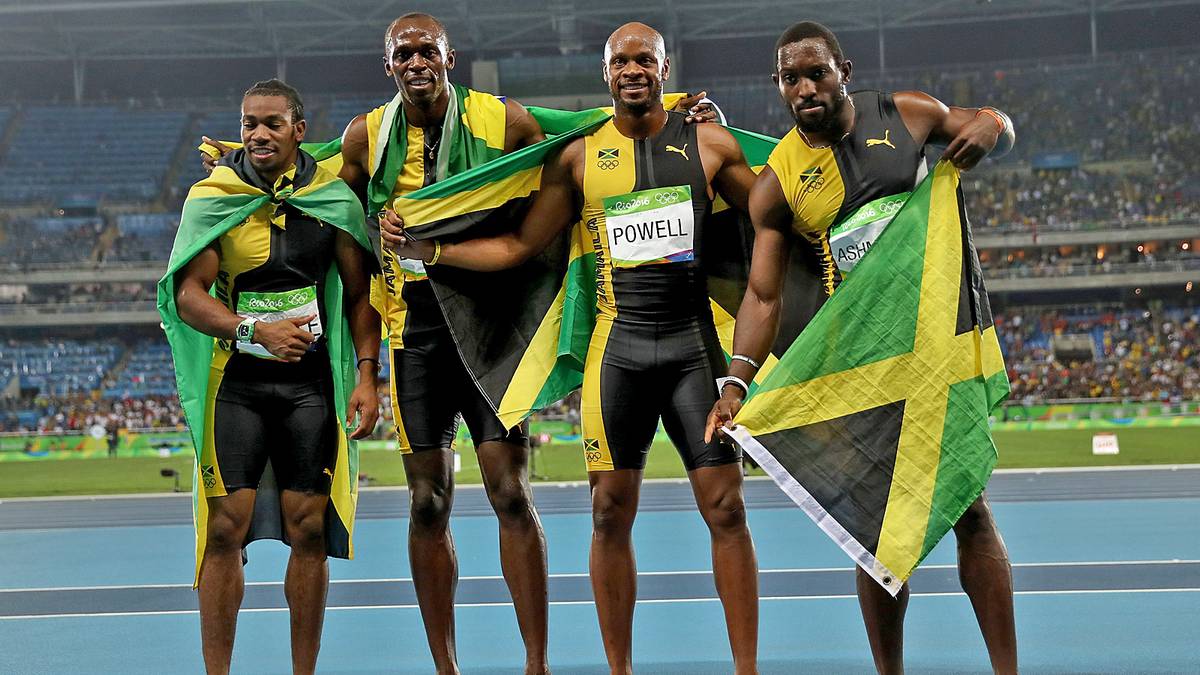 Yohan Blake, Usain Bolt, Asafa Powell und Nickel Ashmeade (v.l.) posieren mit der Nationalflagge Jamaikas