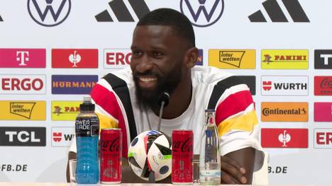 Bei der EM dürfen nur noch die Kapitäne einer Mannschaft mit dem Schiedsrichter auf dem Platz sprechen. Antonio Rüdiger nimmt die neue Regel mit Humor und sieht bei sich selbst schon eine Besserung im Gespräch mit dem Unparteiischen.