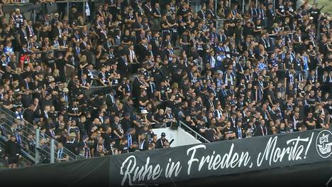 Emotionale Szenen vor dem Anpfiff: Mit einer Kranzübergabe wird zunächst eines verstorbenen Fans gedacht.