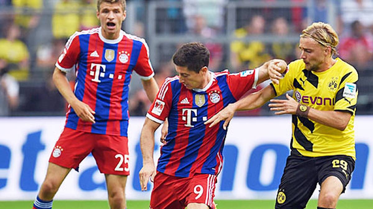 Mit Spannung wird die Rückkehr von Robert Lewandowski (M.) nach Dortmund erwartet. Es gibt Pfiffe, aber nicht so viele wie im Vorfeld erwartet. Der Pole, der aus vor der Saison aus Dortmund nach München wechselt, kann sein so gefürchtetes Angriffsspiel aber lange nicht aufziehen, weil der Grieche Sokratis den 25-Jährigen mit einem tollen Stellungsspiel kalt stellt. Weltmeister Thomas Müller (l.) ist schon wieder im Einsatz