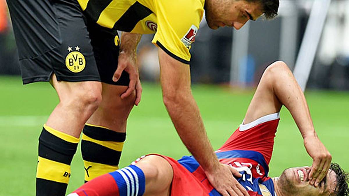 Für die Bayern läuft's nicht gut beim großen Rivalen aus dem Pott. Javi Martinez dreht sich im Luftzweikampf um Schmelzer. Das rechte Bein des Spaniers verdreht sich dabei unglücklich. Der 25-Jährige bleibt mit vom Schmerz verzerrten Blick liegen, muss lange behandelt und schließlich mit der Trage vom Platz gebracht werden. Schon da wissen alle, die zu Bayern halten: Das sieht nicht gut aus!