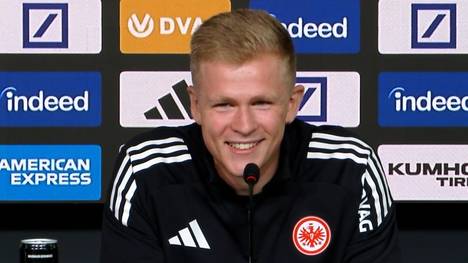 Eintracht Frankfurts Neuzugang Jonathan Burkardt spricht bei seiner Vorstellungs-PK über die Gerüchte, er habe in SGE-Bettwäsche geschlafen und sei wegen der räumlichen Nähe gewechselt.