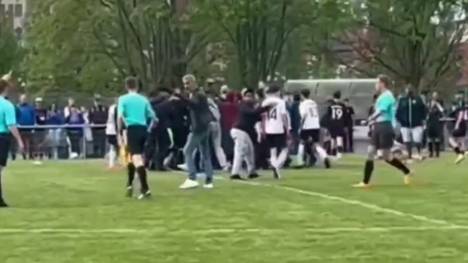 Bei einem Fußballspiel in Frankfurt kam es zu einem Eklat. Nach Abpfiff stürmen mehrere Personen das Spielfeld, wobei eine gezielt auf den Schiedsrichter zu läuft und ihn bedroht.