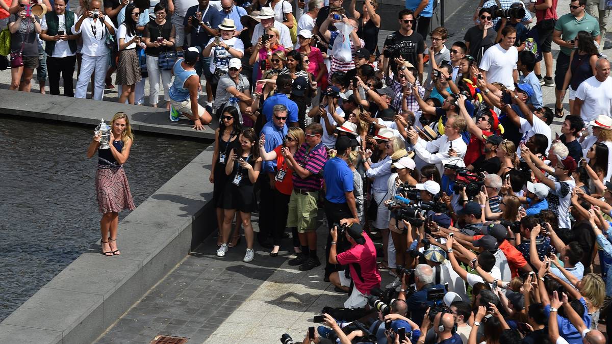 Am Tag nach dem Triumph ist auf der Anlage des National Tennis Center in New York der große Fototermin für die US-Open-Siegerin. Das öffentliche Interesse ist groß. Zahlreiche Fotografen und Zuschauer wollen Angelique Kerber noch einmal sehen