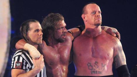 WWE-Vorstand Triple H (M.) war bei WrestleMania dreimal Gegner des Undertaker (r., mit Shawn Michaels)