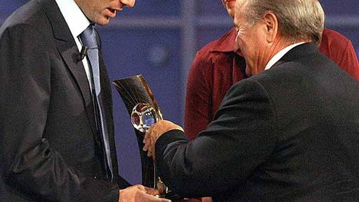 2003: Auch Zinedine Zidane schafft es ein drittes Mal. FIFA-Präsident Sepp Blatter überreicht die Trophäe. Birgit Prinz, selbst dreimalige Weltfußballerin des Jahres, schaut aufmerksam zu