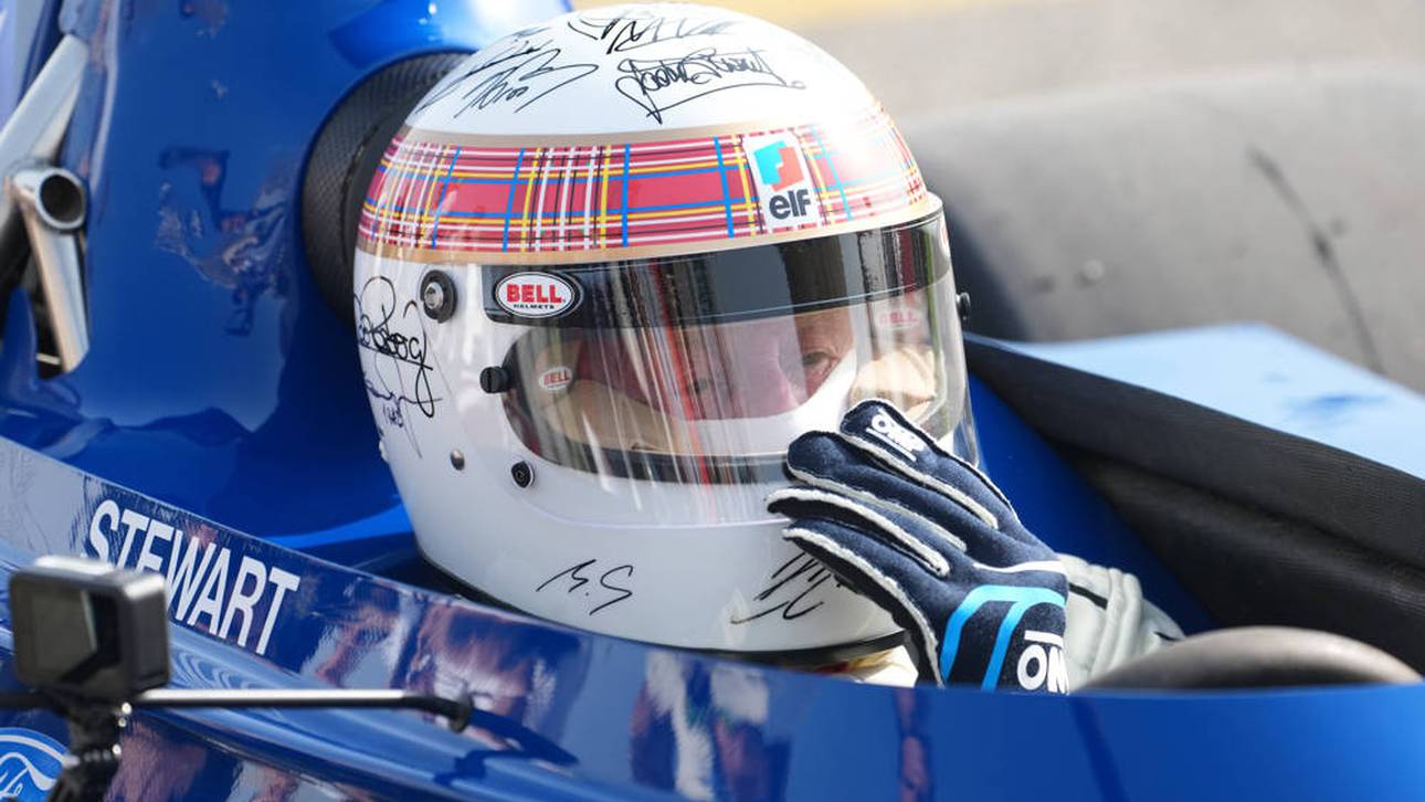 Sir Jackie Stewart mit dem Helm und den Unterschriften