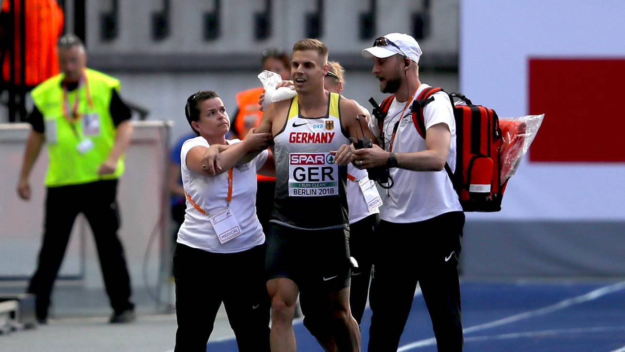 Julian Reus wird von Helfern von der Bahn geleitet