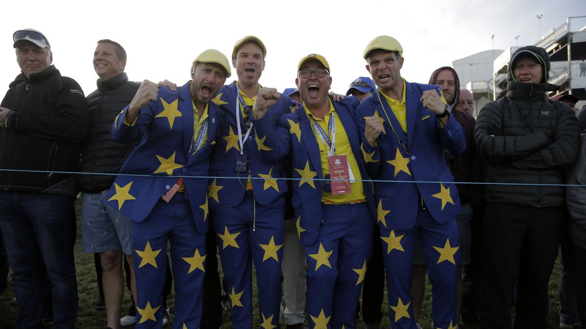 Blauer Anzug mit zahlreichen gelben Sternen auf Sakko und Hose, dazu gelbe Schuhe: So fällt man beim Ryder Cup garantiert auf. Erst recht, wenn es gleich eine Gruppe ist. Ob sie damit die europäische Flagge darstellen wollen? Wohl schon!