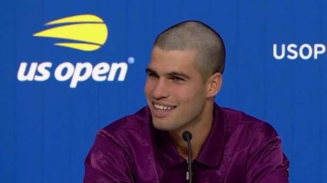 Carlos Alcaraz überrascht bei den US Open mit einem neuen Look. Auf der Pressekonferenz nach seinem ersten Match erklärt er, wie es zu diesem kam. 