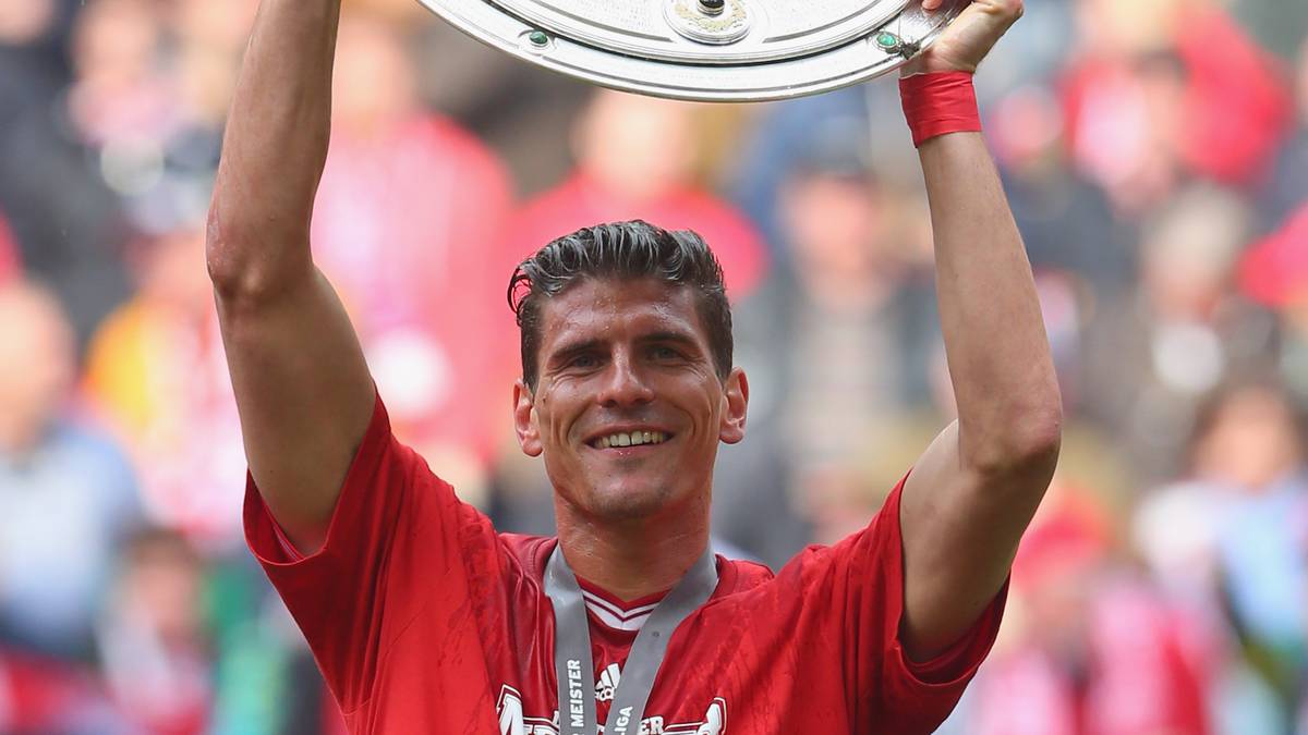 MUNICH, GERMANY - MAY 11:  Mario Gomez of FC Bayern Muenchen celebrates with the Bundesliga trophy following his team's match against Augsburg at the Allianz Arena on May 11, 2013 in Munich, Germany.  (Photo by Alexander Hassenstein/Bongarts/Getty Images)