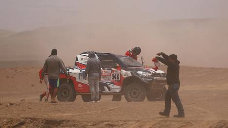 Andre Villas Boas und sein Beifahrer Ruben Faria steigen nach dem Crash an einer Wüsten-Düne wieder in ihr Fahrzeug ein
