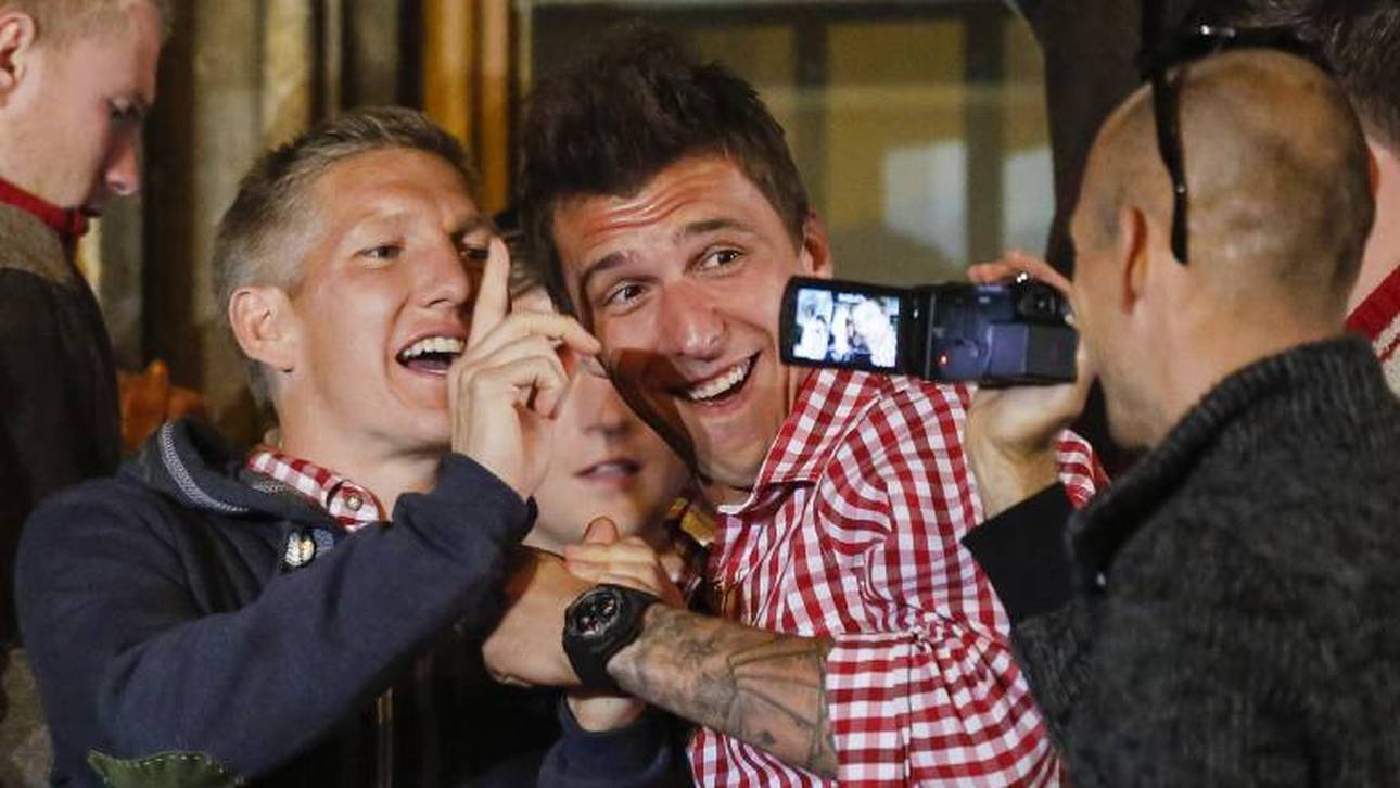 Arjen Robben (r.) filmt Bastian Schweinsteiger und Mario Mandzukic auf der Meisterfeier des FC Bayern