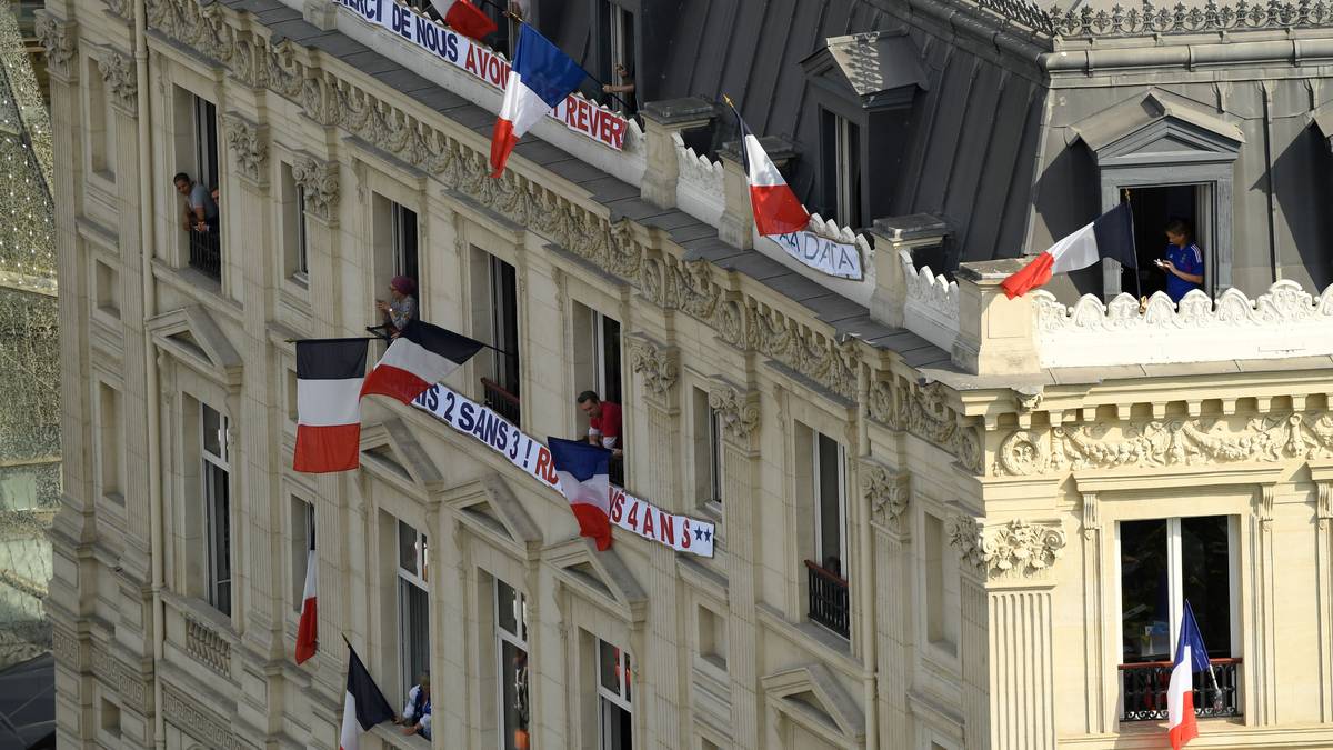 Selbst aus den Fenstern der angrenzenden Häuser werden die Nationalflaggen geschwenkt