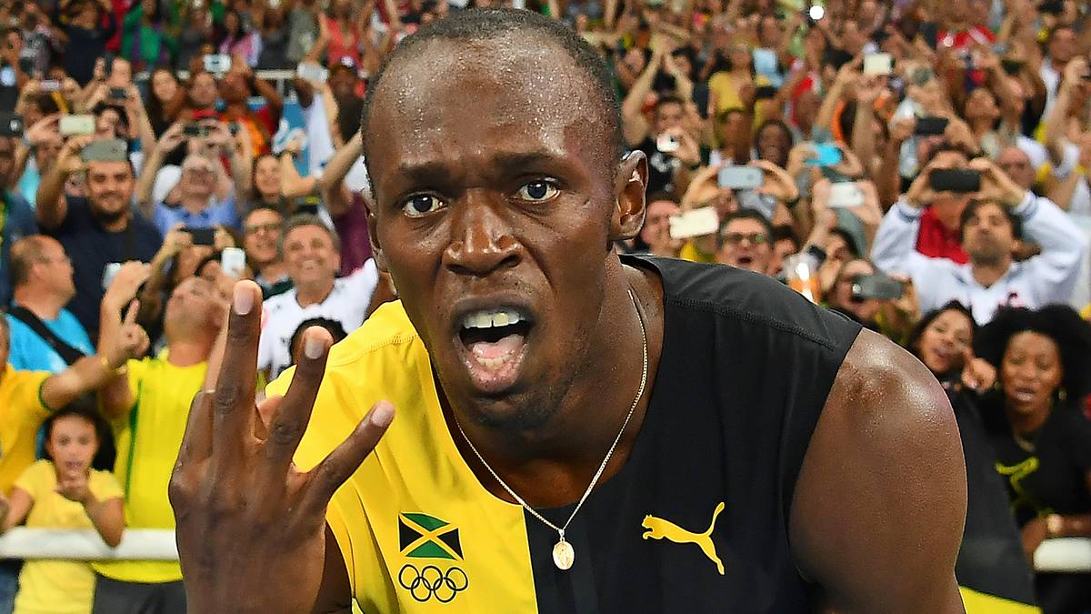 Bolt streckt drei Finger in die Kameras der Fotografen. Bei drei aufeinanderfolgenden Olympischen Spielen gewinnt er jeweils Gold über 100 Meter, 200 Meter und mit der Sprint-Staffel