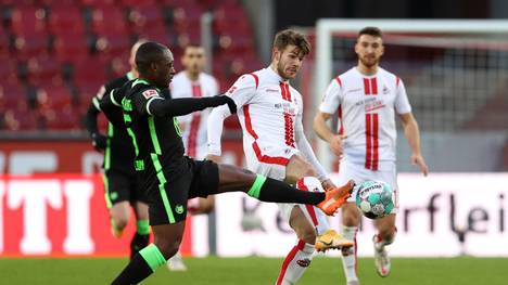 Wolfsburgs Jerome Roussillon (l.) gegen Kölns Premieren-Torschützen Jan Thielmann
