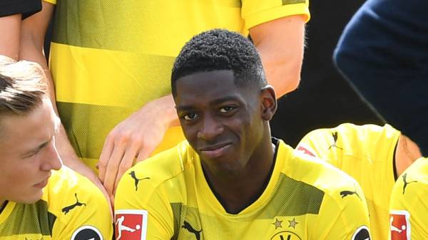Dortmund's French midfielder Ousmane Dembele (C) smiles as he has taken seat for the team photo during a press event of German first division Bundesliga football club Borussia Dortmund on August 9, 2017 in Dortmund, western Germany. / AFP PHOTO / PATRIK STOLLARZ        (Photo credit should read PATRIK STOLLARZ/AFP/Getty Images)