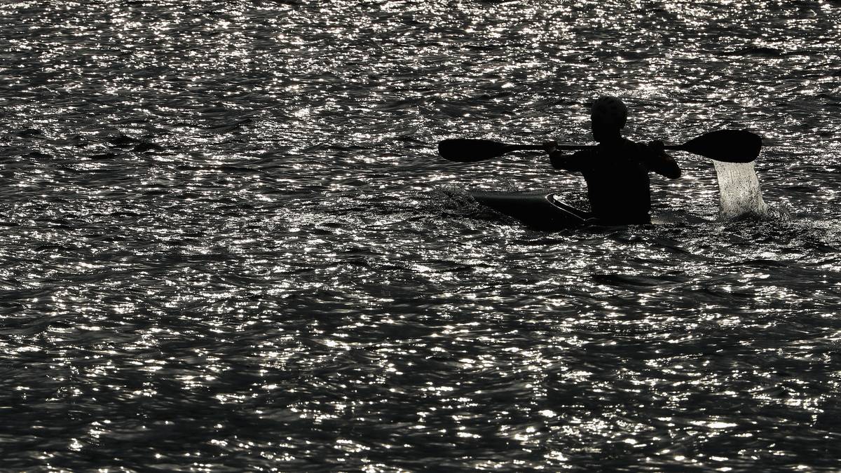 Werde eins mit deiner Umgebung! Dieser Kajak-Fahrer ist im weitem Meer kaum auszumachen