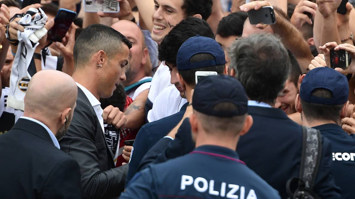 Der Weltfußballer schreibt fleißig Autogramme, umringt von Polizisten und Sicherheitskräften. Die Fans freut es natürlich