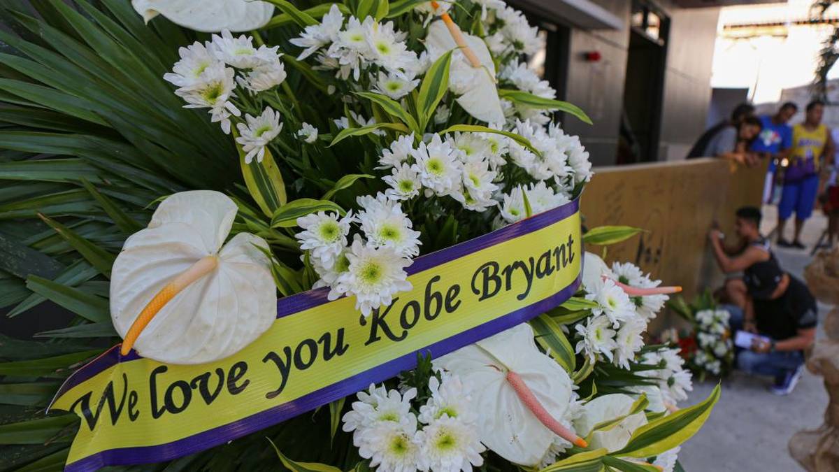 Vor der "House of Kobe" Halle in Manila, die anlässlich Kobes Besuch 2016 errichtet wurde, liegen ebenfalls Blumen. Die Aufschrift "Wir lieben dich Kobe Bryant" zeigt die Beliebtheit Kobes in Manila