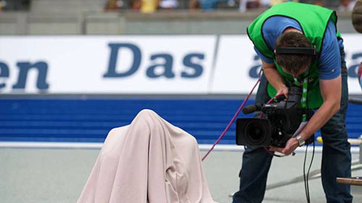 Stabhochspringerin Yelena Issinbayewa aus Russland konzentriert sich mit einer Decke über dem Kopf