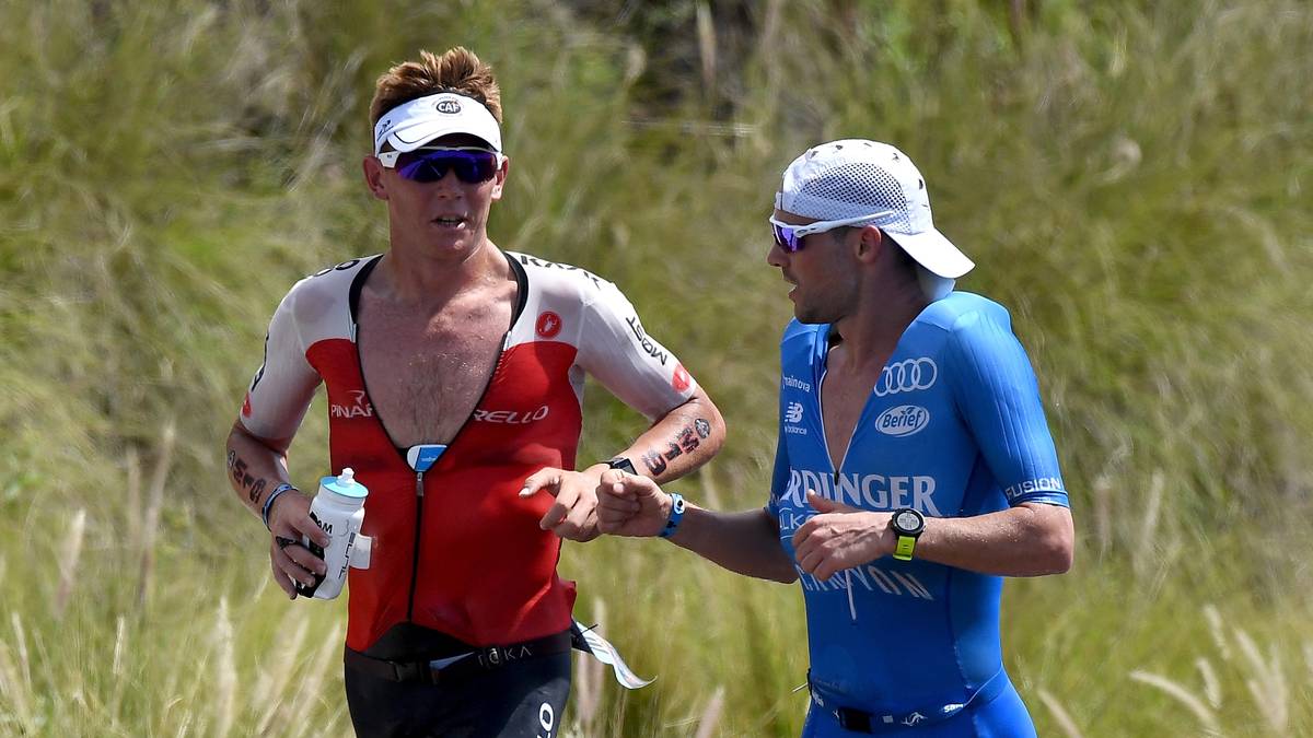 Der Sportsgeist unter Triathleten ist herausragend: So geben sich Patrick Lange und Cameron Wurf die Faust, als der Deutsche auf der Laufstrecke den bis dato führenden Wurf als Spitzenreiter ablöst