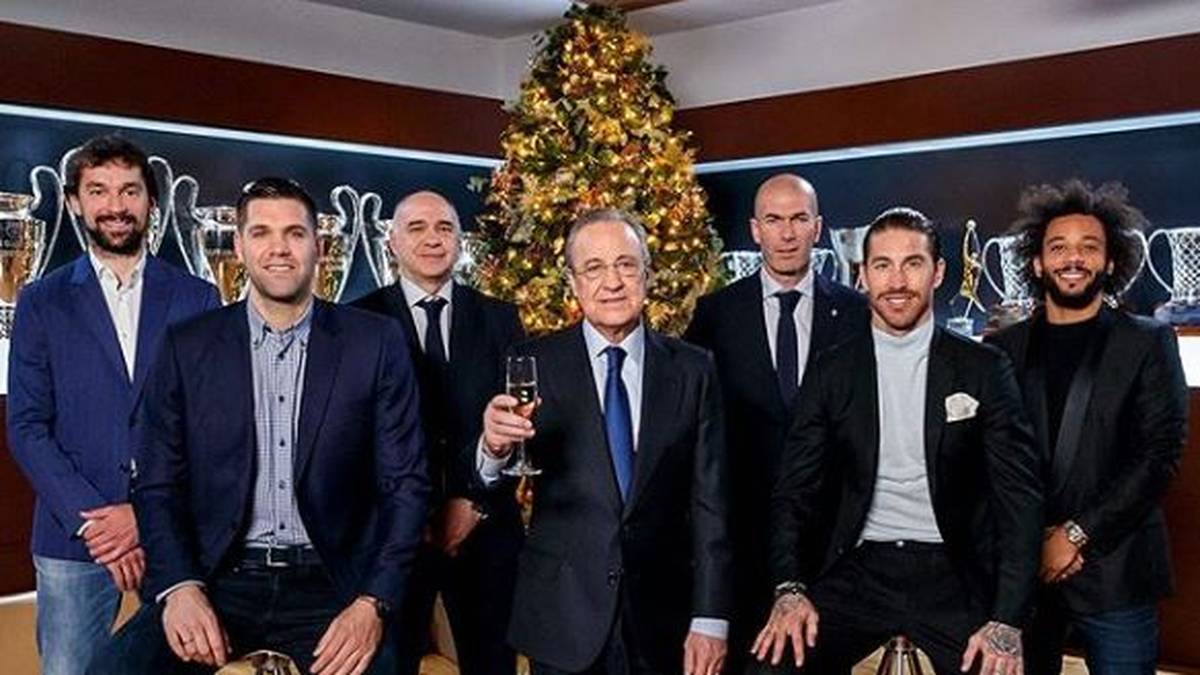 Schöne Weihnachtsgrüße von den Königlichen! Um Real Madrids Präsident Florentino Pérez (M.) haben sich die Basketballer Sergio Llull und Felipe Reyes mit Trainer Pablo Laso (v.l.) sowie die Fußballer Marcelo und Sergio Ramos mit ihrem Trainer Zinédine Zidane (v.r.) am Weihnachtsbaum versammelt