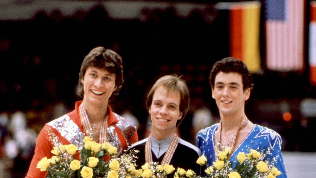 Scott Hamilton (C) of the United States smiles, fl Bei der Weltmeisterschaft 1983 in Helsinki lief Norbert Schramm (l.) zu Silber