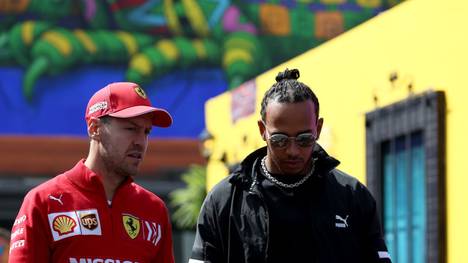 MEXICO CITY, MEXICO - OCTOBER 24: Sebastian Vettel of Germany and Ferrari and Lewis Hamilton of Great Britain and Mercedes GP talk as they walk in the Paddock during previews ahead of the F1 Grand Prix of Mexico at Autodromo Hermanos Rodriguez on October 24, 2019 in Mexico City, Mexico. (Photo by Charles Coates/Getty Images)